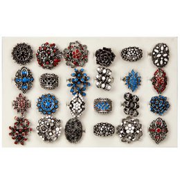 Assortment of fashion rings featuring various styles, colors, and shapes. Includes rings with floral, geometric, and abstract designs, some with colorful gemstones or crystals. Suitable for statement jewelry or accessorizing.