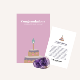  A purple crystal cluster with a lit candle on a pink background. The text "Congratulations" is displayed prominently.