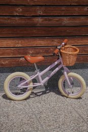 Balancecykel i pastel pink farve med flettet kurv Isabelle Rose