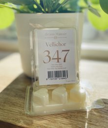 Wax melt with notes of rose, fig, and mint. Rectangular shape with a light beige color.