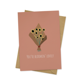 A pink greeting card with a floral bouquet design and the text "You're bloomin' lovely!" The card is suitable for friendship occasions.