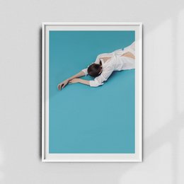 A poster featuring a person in a white outfit lying on a teal background.