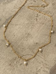 A delicate gold necklace with mini pearl accents, perfect for adding a touch of elegance to any outfit.