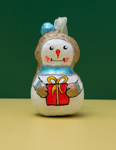 Handgemaakte sneeuwpop van papier-maché met een cadeau