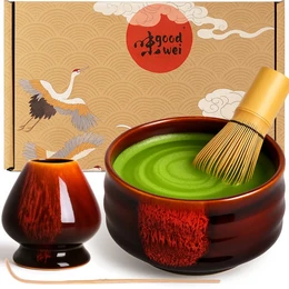 The Matcha Set 4-tlg. includes a Teeschale Chawan, an 80er Matchabesen, a Halter, and a Löffel. The set is available in various colors and patterns, including Akai, Bamboo, Black Marmor, Burashi, Goma, Gurei, Hasunomi, Kiku, Kiri, Kori, Kumo, Kuro Black, Kuro, Magnolia, Menouseki, Midori, Minto, Miyuki, Moya, Pink Marmor, Pinku, Plum, Rindo, Rokku Kuro, Rokku Shiro, Safaia, Sakura, Seiun, Shiro, Sumi, Tetsu, Uji, White Marmor, and Yogan. The set includes a ceramic bowl, a bamboo whisk, a whisk holder, and a spoon, all in a traditional Japanese style.