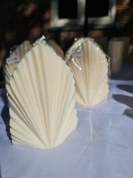  Large, ivory-colored sheet candles with a pleated, fan-like design. Suitable for use as dinner candles or home decor.