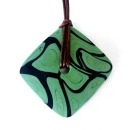 Handmade Murano glass necklace pendant in various colors including green, white, brown, orange, and black. The pendant features a unique swirling pattern created using the technique of colored glass fusion and cold polishing.