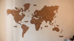 Wooden world map wall art, cork texture, continents puzzle, DIY wall decoration, brown natural material.