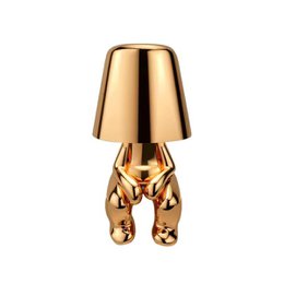  Gold metallic table lamp with decorative bear-shaped base, modern cylindrical shade, elegant accent lighting.