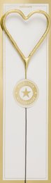 A tall, round white candle with a gold heart-shaped frame and a gold star-shaped decoration.