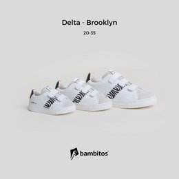 White casual sneakers with velcro straps, suitable for kids' sports activities.