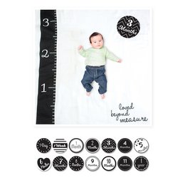 Soft, cozy swaddle blanket with a baby's first year milestone tracker. Features a neutral gray and white polka dot design, perfect for baby boys or girls. Includes icons to mark special moments during baby's first 12 months.