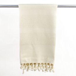 Organic cotton Hammam towel in natural color with tasseled edges, suitable for use as a bath towel or beach wrap.