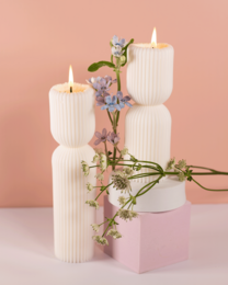 Tall, grooved white pillar candles in two sizes, perfect for home decor and ambiance.