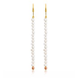 Gold and pearl statement earrings with a long, elegant design.