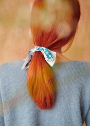 Colorful ribbon scarf with floral pattern, made of woven material, suitable for accessorizing outfits.