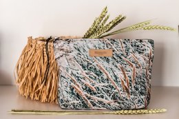 A rectangular clutch with a textured, multicolored pattern and a tassel accent. The clutch appears to be made of a durable, woven material.