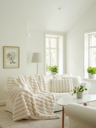 Soft, cozy ivory-colored throw blanket with a textured, wavy pattern. Made of high-quality materials for a luxurious feel. Ideal for adding warmth and style to any living space.