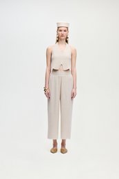  Linen natural pants in a neutral beige color, featuring a high-waisted, wide-leg silhouette and a tie detail at the waist.