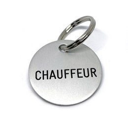 Silver-colored round keychain with the word "CHAUFFEUR" printed on it. Suitable for car keys or as a gift for a chauffeur.
