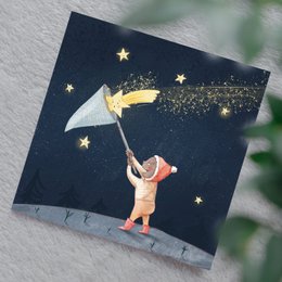 A postcard featuring a whimsical illustration of a person catching stars in the night sky, with a starry background and a crescent moon. The postcard is likely intended for Christmas or holiday-themed use.