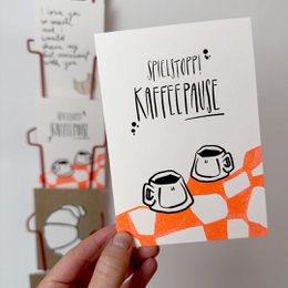  "Postcard with a playful illustration of coffee cups and the text 'Spielstopp! Kaffeepause' (Coffee break!). The postcard is suitable for coffee lovers and friends."