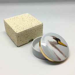 Una piccola scatola rotonda con un cigno