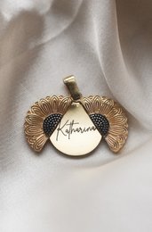Gold-toned sunflower pendant necklace with engraved disc.