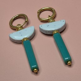 Elegant statement earrings featuring a light blue semi-circular shape and a teal vertical bar, accented with gold-tone hardware.