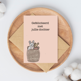 Congratulatory card featuring a rabbit and a mouse in a basket, celebrating the birth of a daughter.