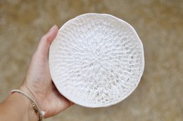 Ceramic serving bowl in a sand color, featuring a textured, circular design. Suitable for serving snacks, appetizers, or decorative display.