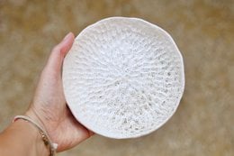 Ceramic serving bowl in a sand color, featuring a textured, circular design. Suitable for serving snacks, appetizers, or decorative display.