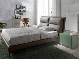 Bett mit Kunstlederbezug und Kissen