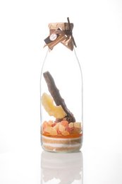 Exotic rum preparation in a glass bottle with various spices and herbs.