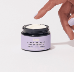 Organic repairing cream in a black jar. The cream is white in color and has a smooth, creamy texture. The jar has a simple, minimalist design.