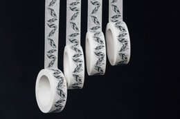 Decorative washi tape featuring a repeating pattern of feather designs in black and white. The tape has a matte finish and can be used for various crafting and decorative purposes.