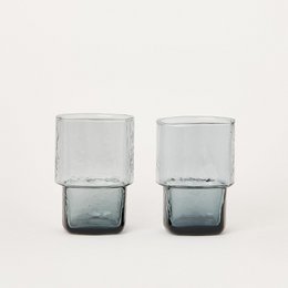A set of two smoky gray water glasses with a square, minimalist design.