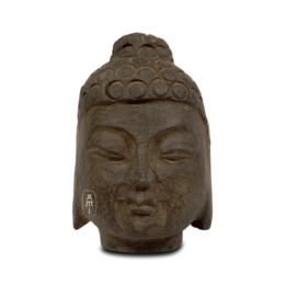 Small Buddha head statue made of stone with intricate details and a serene expression.