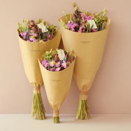 Dried flower bouquet in pink and yellow hues, featuring a variety of dried flowers and grasses arranged in a rustic, natural style.