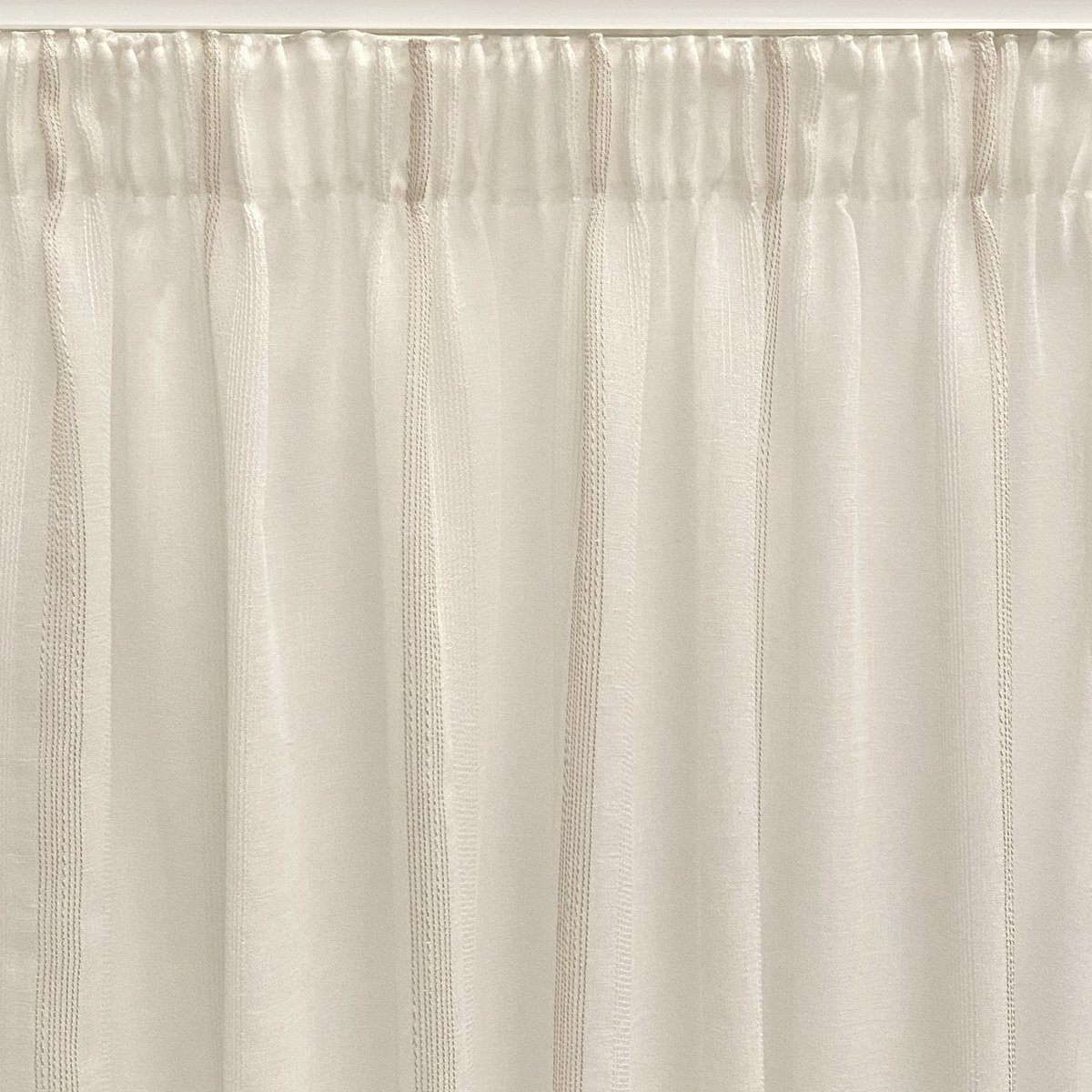 Cortina translúcida de color beige confeccionada en cinta multifunción (cinta fruncidora o pasabarras). Visillo Jacquard de raggi verticali fabbricato con materiali riciclati e di qualità. Colori naturali e caldi. Cortinas para salón, dormitorio