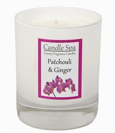 A tall, round white candle in a glass tumbler with a pink and purple floral label. The candle is scented with patchouli and ginger.