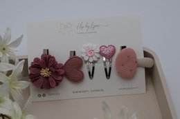  Set of decorative hair clips in gold, silver, and pink colors with floral and heart-shaped designs.