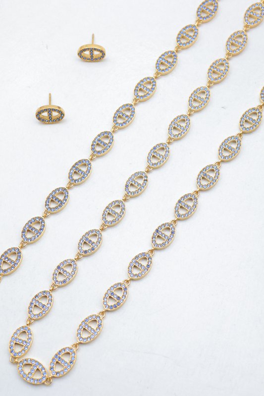 Ensemble assorti comprenant un collier, un bracelet en chaîne et une paire de boucles d'oreilles puces. Chaque bijou est composé d'une succession de maillons en forme de maille marine entièrement pavés de petits strass scintillants.