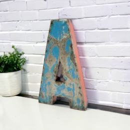 Decorative letter 'A' made from recycled oil barrels, available in various sizes (22 cm or 50 cm) and colors (black, blue, green, red, red-orange, turquoise, white, yellow, bicolor).
