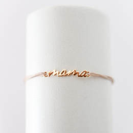 Gold-toned charm bracelet with "mama" and "mini" charms, available in black, beige, and gold color variants.