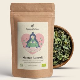 Organic tea labeled "No. 1 Mum" in a brown paper bag. The tea leaves appear to be dried and green in color. The packaging includes icons indicating the tea is organic, natural, and sustainably produced.