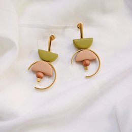 Olive and nude statement earrings with a unique spiral design.