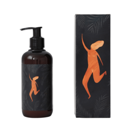 Hand cream with art by Natascha, featuring an orange abstract figure on a black background. Moisturizing hand cream in a pump bottle.
