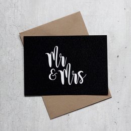 A black card with the text "Mr & Mrs" in white cursive font, suitable for a wedding or anniversary celebration.