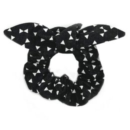 A black and white scrunchie with a bow, featuring a repeating triangle pattern. The scrunchie is part of the "CACHOU" collection.